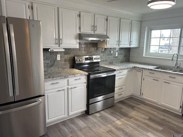 kitchen with white cabinets, appliances with stainless steel finishes, under cabinet range hood, and a sink
