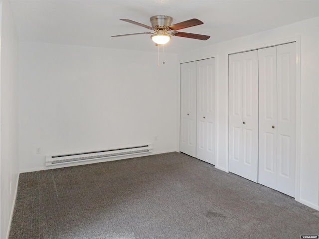 unfurnished bedroom featuring baseboard heating, carpet floors, two closets, and a ceiling fan