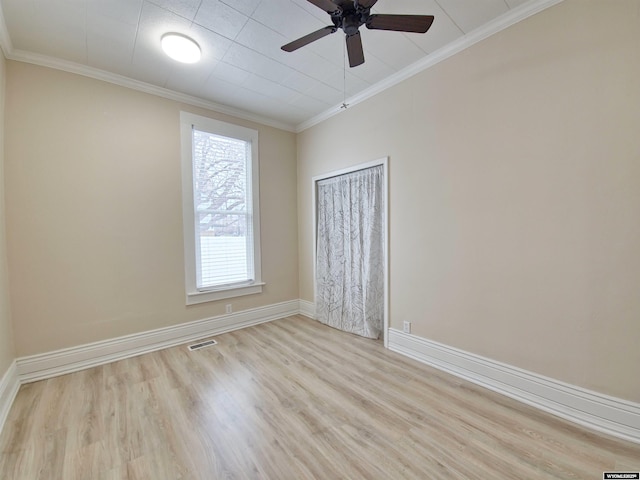 empty room featuring wood finished floors, crown molding, and a ceiling fan