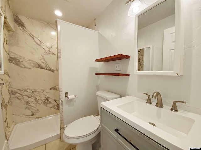 bathroom with toilet, vanity, and a marble finish shower