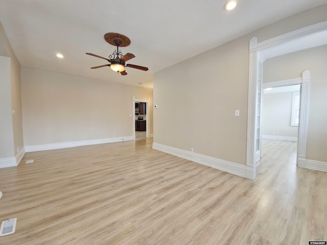 unfurnished room featuring visible vents, light wood finished floors, baseboards, and a ceiling fan
