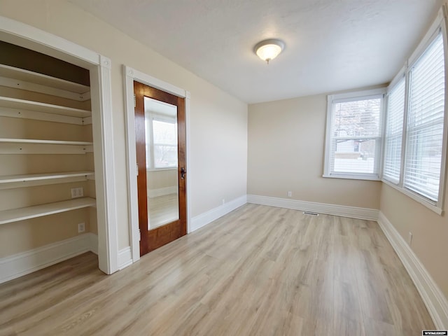 interior space featuring wood finished floors, visible vents, and baseboards