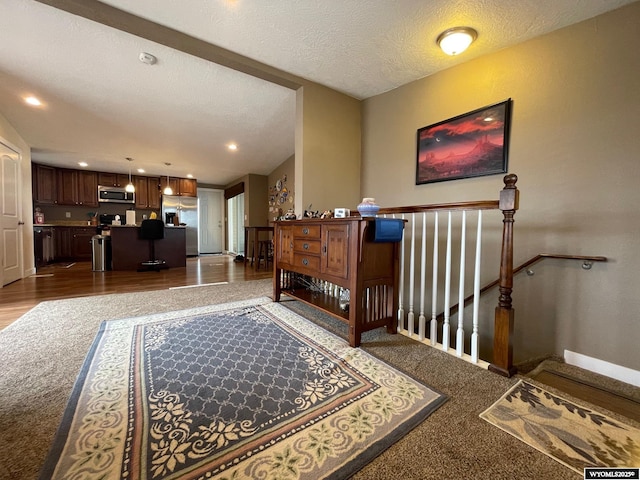 interior space featuring carpet, baseboards, a textured ceiling, and recessed lighting