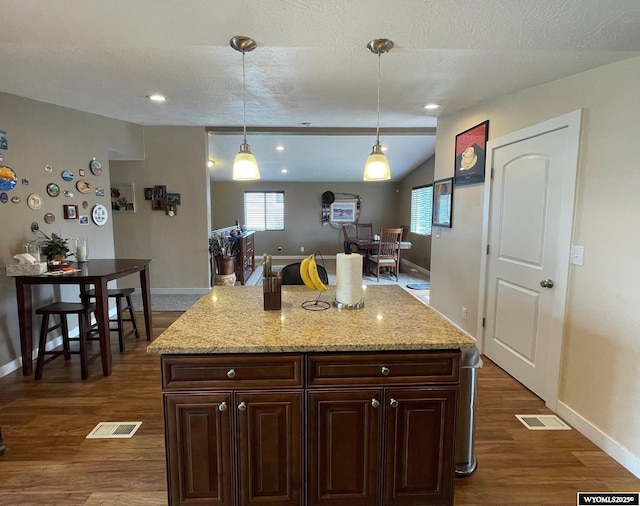kitchen featuring baseboards, visible vents, and dark wood-style floors