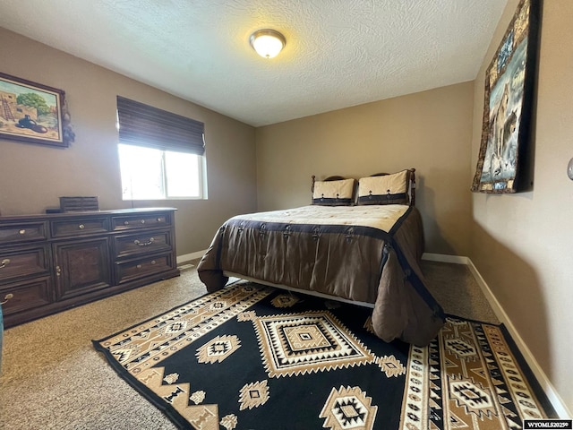 carpeted bedroom featuring baseboards and a textured ceiling