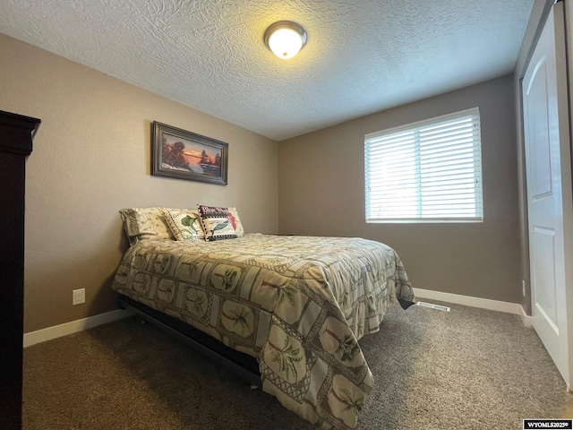 bedroom featuring baseboards, carpet flooring, and a textured ceiling
