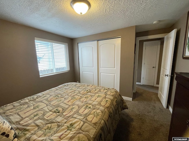 carpeted bedroom with baseboards, a textured ceiling, and a closet