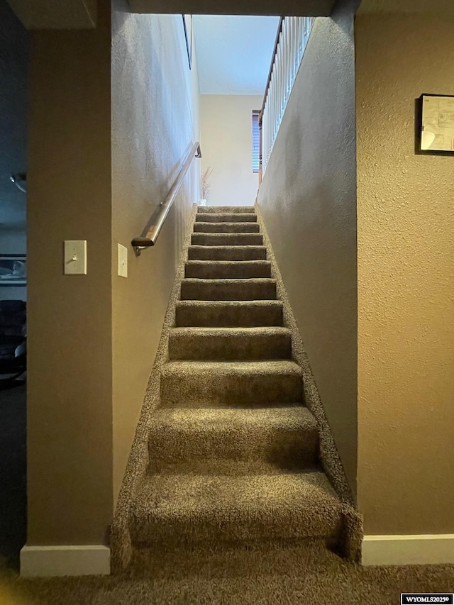 staircase featuring a textured wall