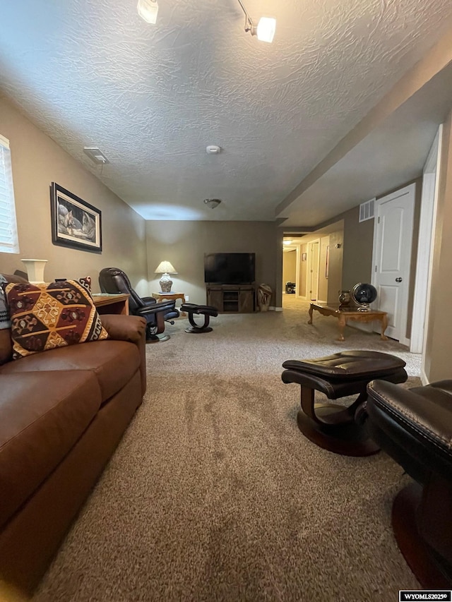 carpeted living room with visible vents and a textured ceiling
