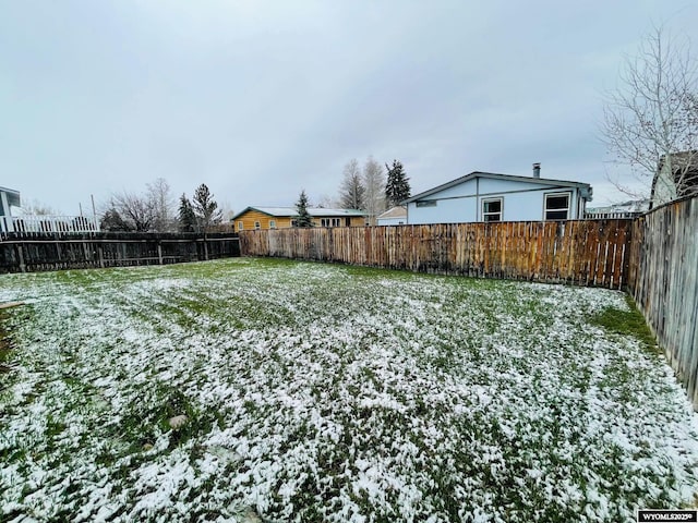 yard covered in snow featuring a fenced backyard