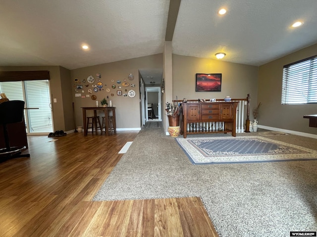 living area featuring wood finished floors, vaulted ceiling, baseboards, and recessed lighting