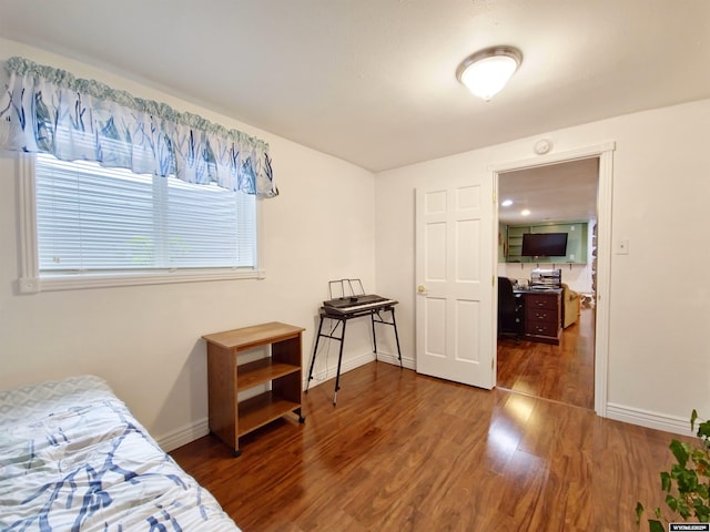 bedroom featuring baseboards, multiple windows, and wood finished floors