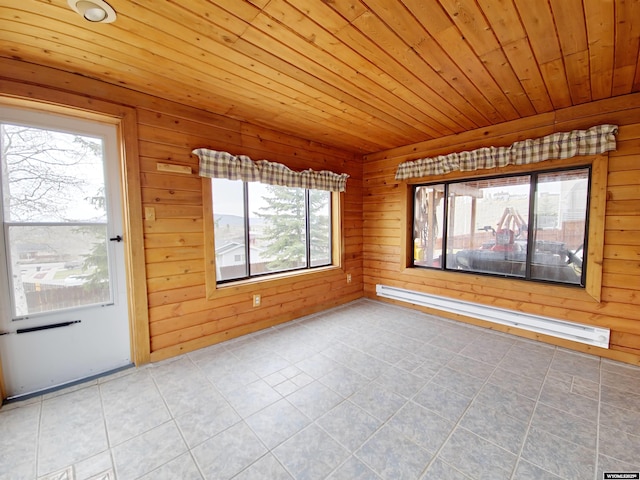 spare room featuring a baseboard heating unit, a healthy amount of sunlight, and tile patterned floors