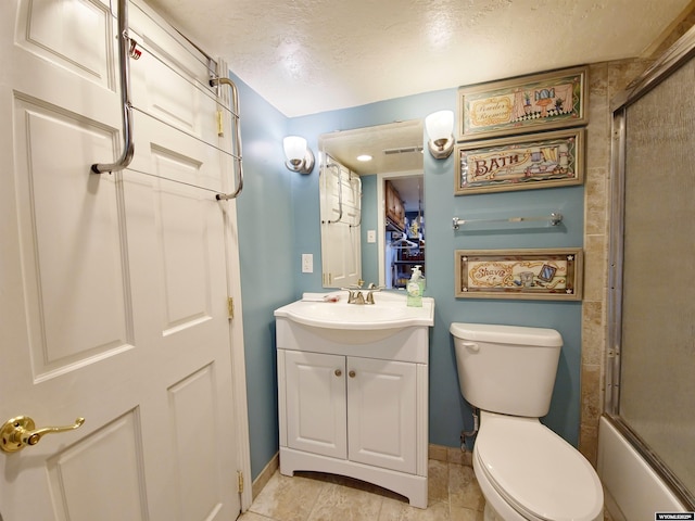 full bath featuring baseboards, toilet, vanity, and a textured ceiling