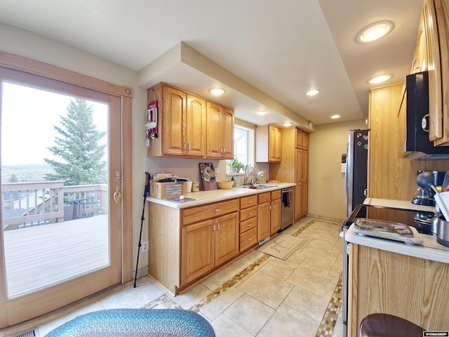kitchen with recessed lighting, stainless steel appliances, light countertops, a sink, and baseboards