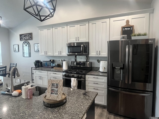 640 Lynn Ct, Green River, WY 82935 - kitchen featuring stainless steel appliances, vaulted ceiling, white cabinetry, and dark wood-style flooring