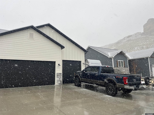 640 Lynn Ct, Green River, WY 82935 - view of side of home with board and batten siding, an attached garage, a mountain view, and driveway