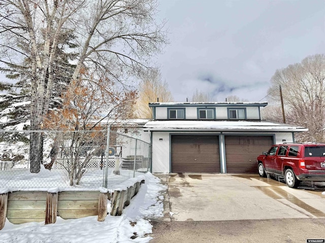 traditional-style home with a garage and fence