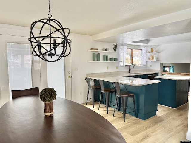 kitchen with a peninsula, open shelves, a sink, and an inviting chandelier