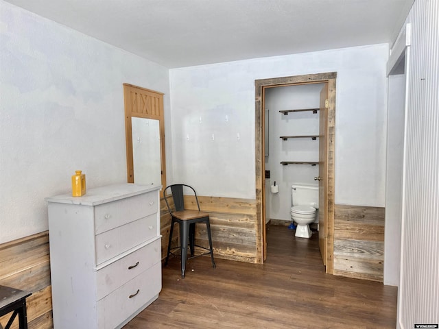 bedroom featuring ensuite bathroom and wood finished floors