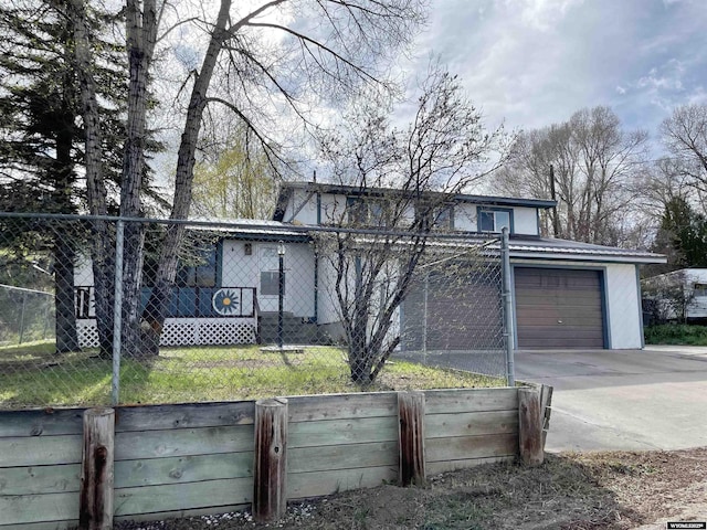 view of front facade featuring driveway and fence
