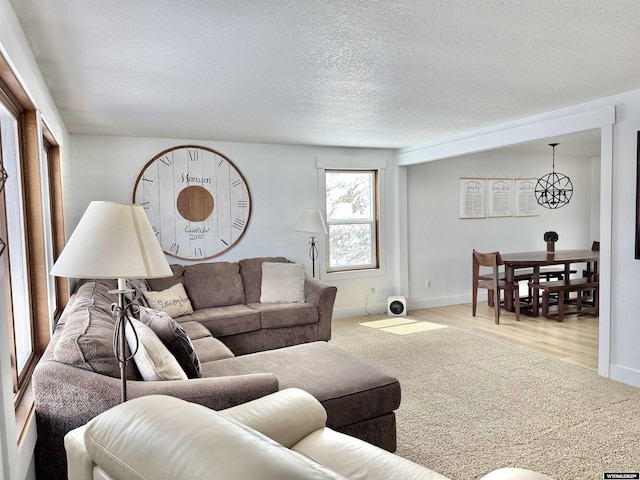 living area featuring wood finished floors, baseboards, and a textured ceiling