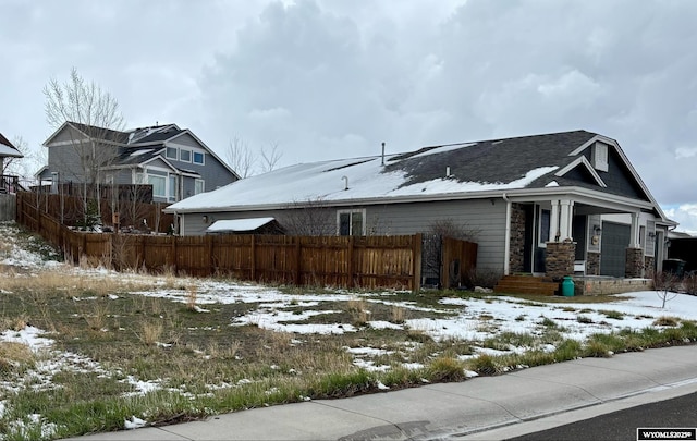 view of home's exterior with fence and stone siding