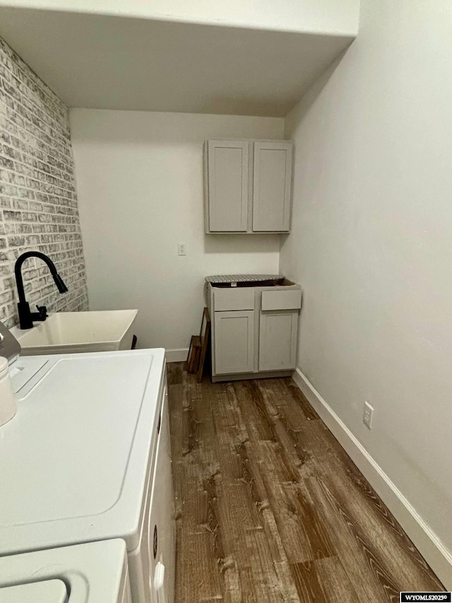 laundry area with dark wood finished floors, washing machine and clothes dryer, and cabinet space