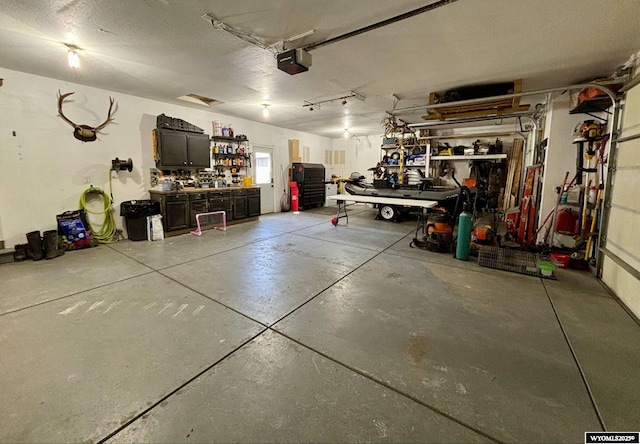 garage with a workshop area and a garage door opener