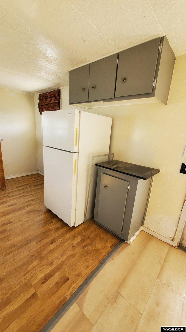 2884LOT1119 Yellowcreek Rd, Evanston, WY 82930 - kitchen featuring light wood-style flooring, gray cabinetry, a textured ceiling, and freestanding refrigerator