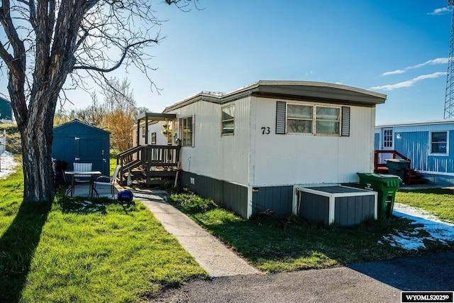 view of home's exterior with an outbuilding, a yard, and a shed