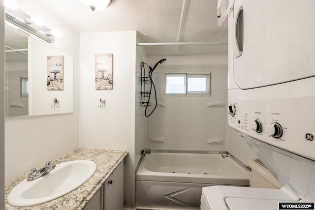 full bath with toilet, stacked washer and clothes dryer, vanity, and tub / shower combination
