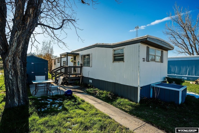 view of side of property with crawl space, a storage unit, and an outbuilding
