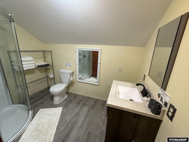 full bath featuring toilet, a stall shower, vaulted ceiling, wood finished floors, and vanity