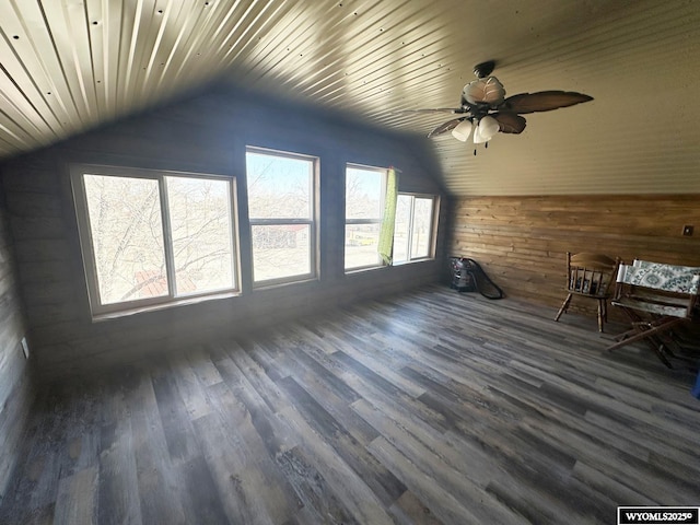 additional living space featuring lofted ceiling, dark wood-style floors, wooden walls, a ceiling fan, and wooden ceiling