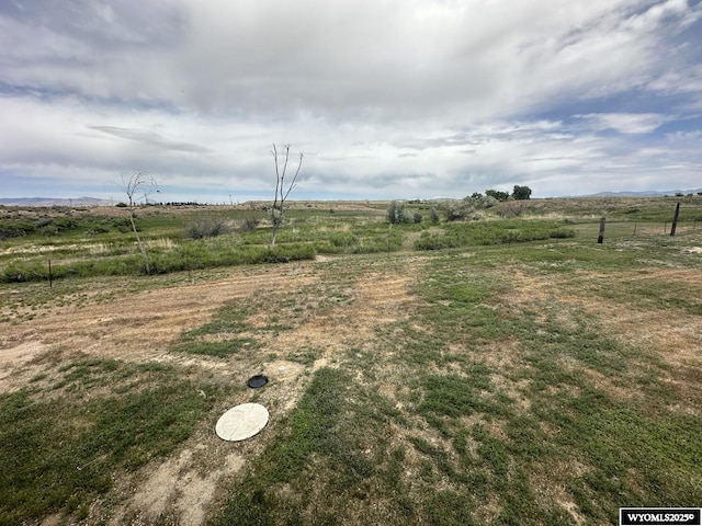 view of yard featuring fence and a rural view