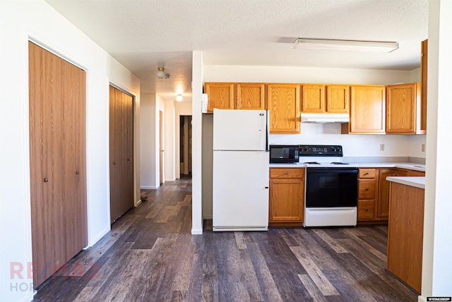 kitchen with freestanding refrigerator, black microwave, light countertops, under cabinet range hood, and electric stove