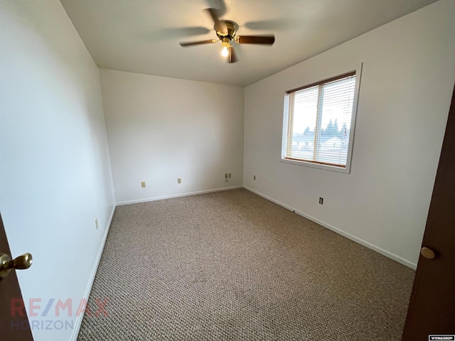 carpeted empty room with a ceiling fan and baseboards