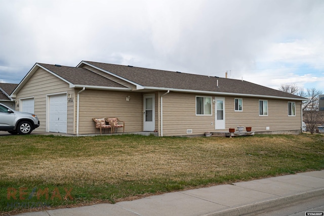 view of front of house with an attached garage, roof with shingles, and a front yard