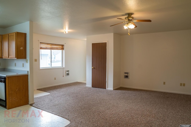 interior space featuring heating unit, a ceiling fan, baseboards, and light colored carpet