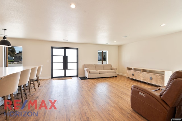 living room with baseboards, light wood-style floors, and recessed lighting