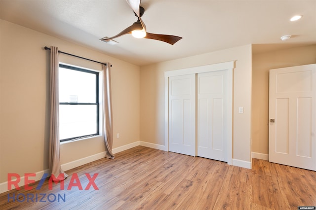 unfurnished bedroom featuring a closet, baseboards, a ceiling fan, and light wood-style flooring
