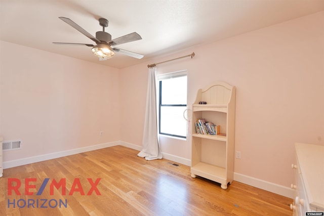 unfurnished room featuring baseboards, a ceiling fan, visible vents, and light wood-style flooring