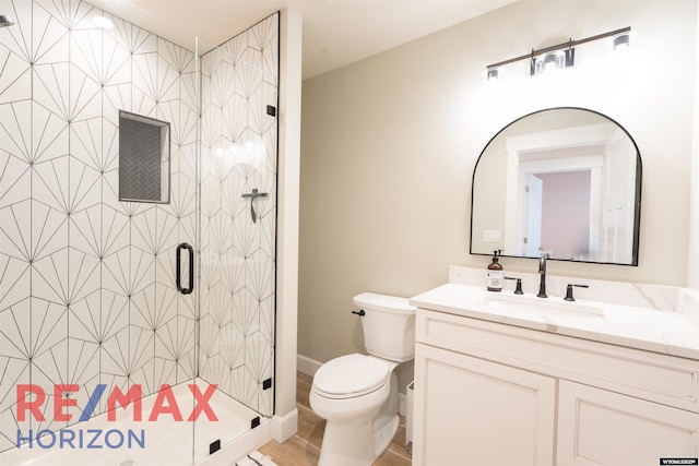 full bath with vanity, a shower stall, and toilet