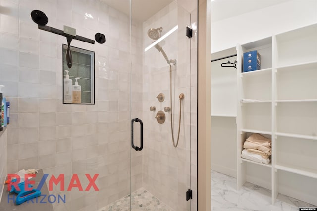 bathroom with a shower stall and marble finish floor