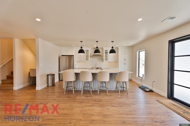 kitchen featuring light countertops, light wood-type flooring, white cabinetry, and a large island