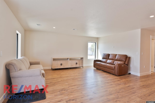 living room with baseboards, light wood-style flooring, and visible vents