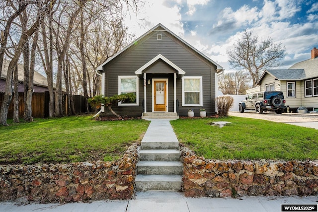 bungalow-style house featuring a front lawn and fence