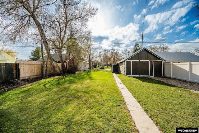 view of yard with a pole building, an outbuilding, and fence