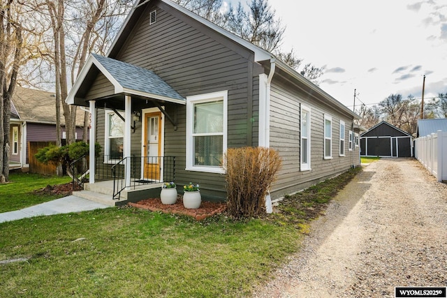 bungalow-style home featuring a front lawn and fence